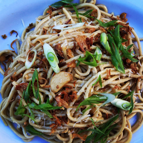 Starry Kitchen garlic noodles melted parmesan cheese green onions cut on a bias fried shallots fried whole garlic cloves